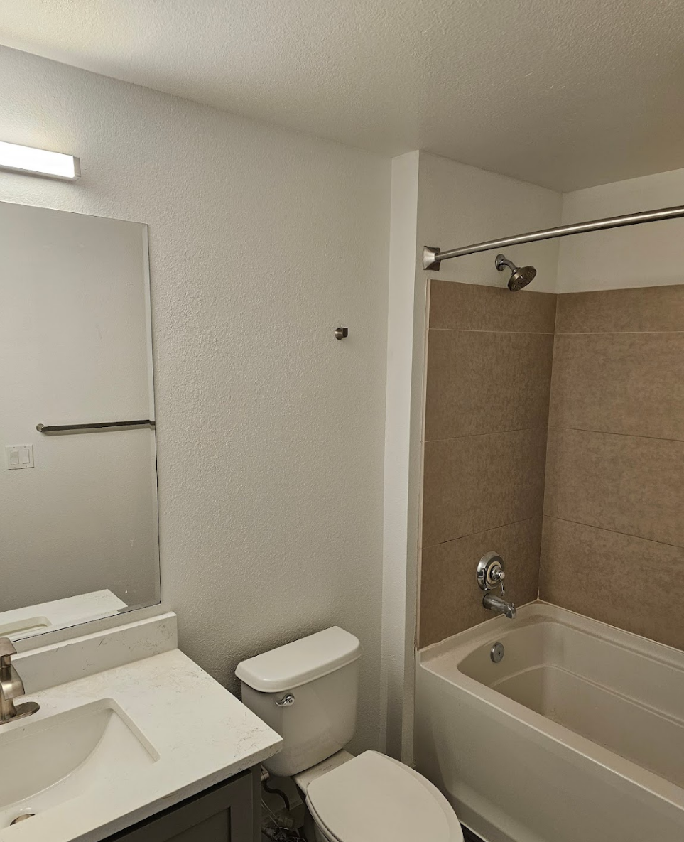 Compact bathroom featuring clean white fixtures and tiled walls