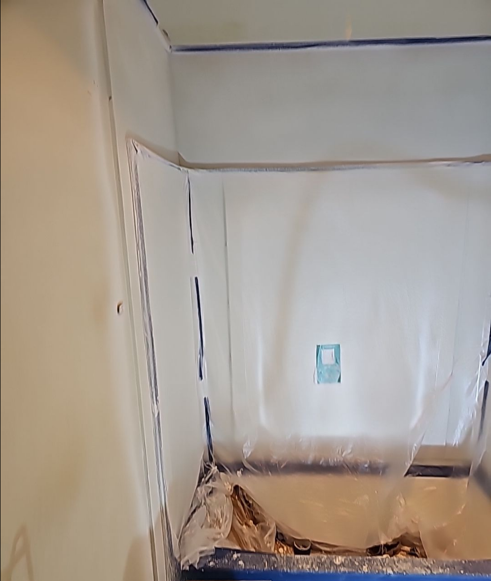 Initial stages of bathroom renovation with protective covering