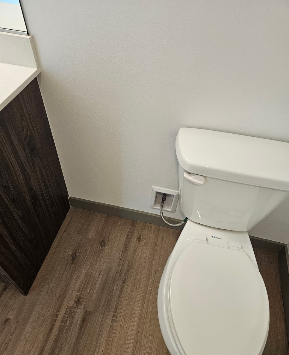 Modern bathroom with wood-inspired flooring and clean white fixtures