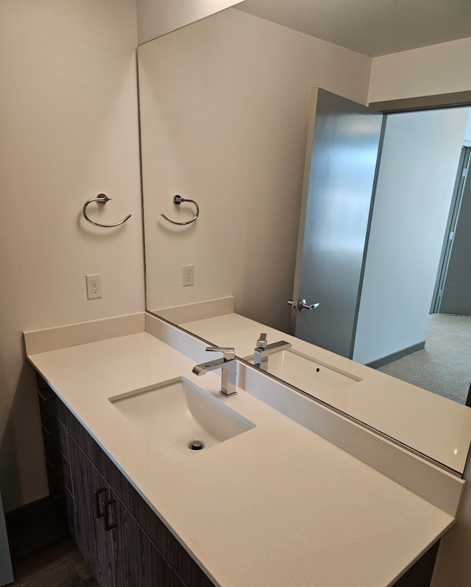 Double vanity with sleek countertops and ample lighting