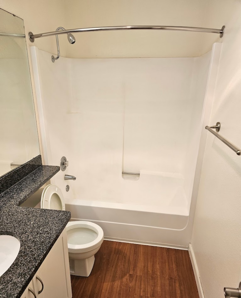 Updated bathroom with clean lines and warm wood flooring