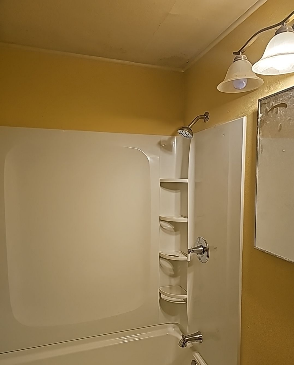 Bathtub area with built-in shelving for added storage