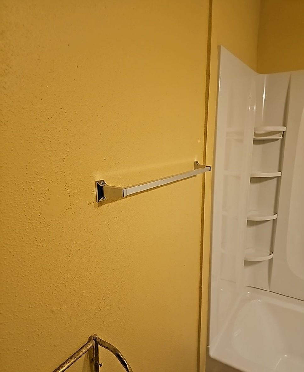 Shower space featuring clean finishes and bright walls