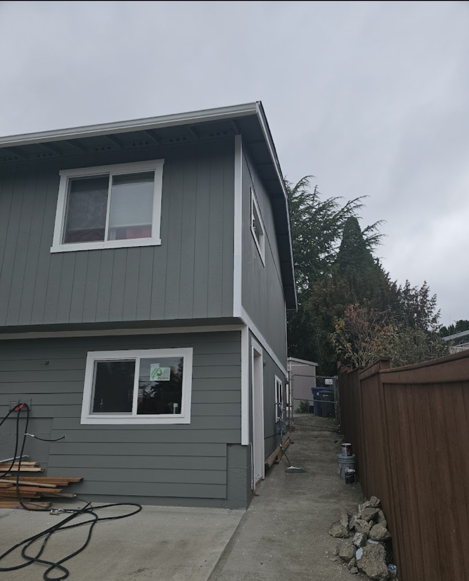 Exterior renovation highlighting spacious yard and improved siding