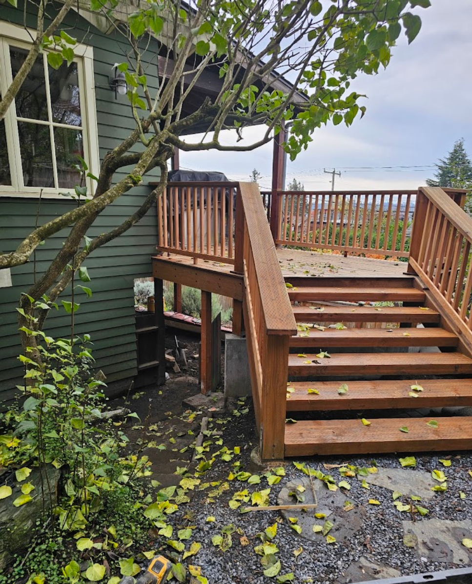 Redesigned backyard stairs and deck surrounded by greenery