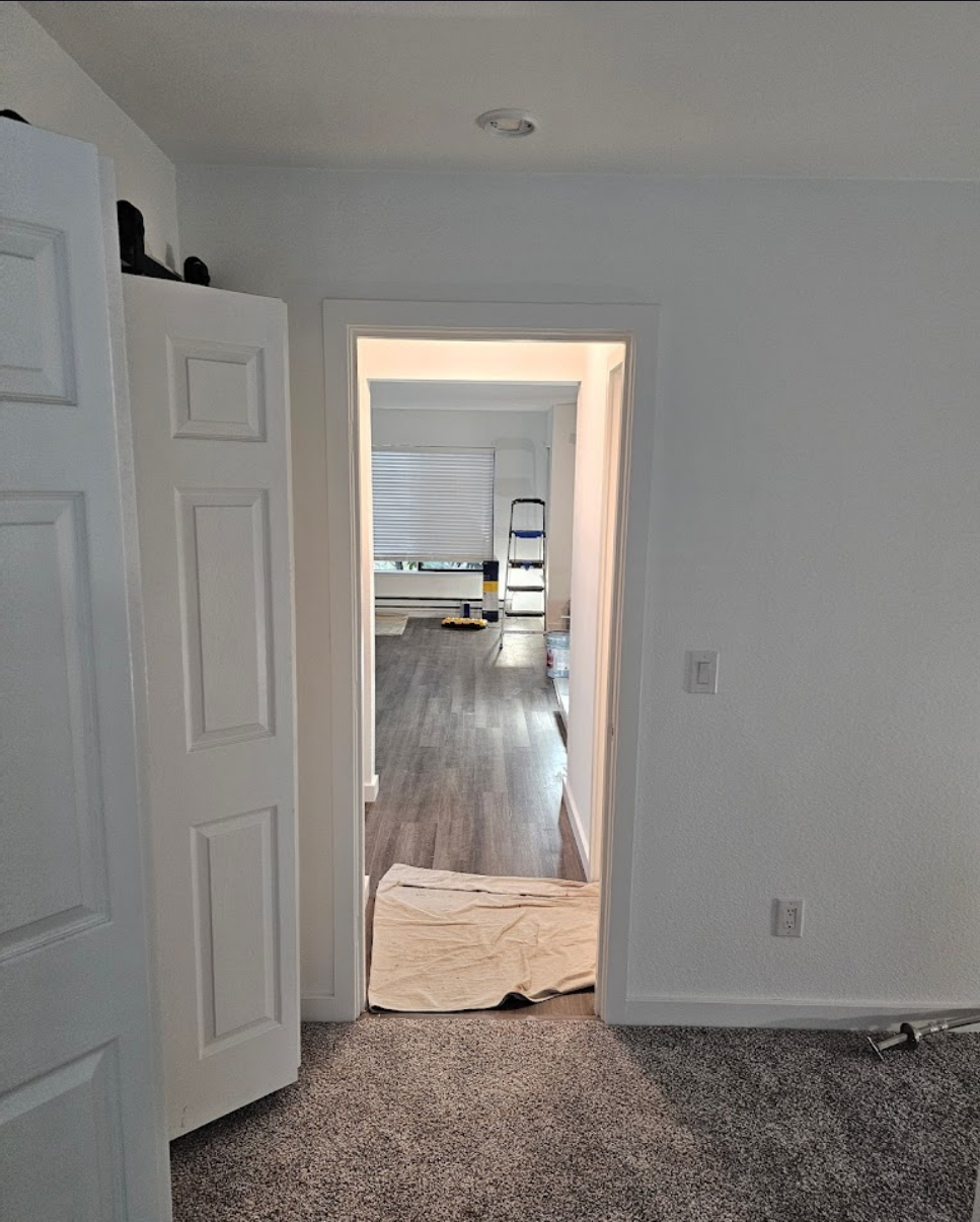 Hallway leading to a newly added room with updated lighting.