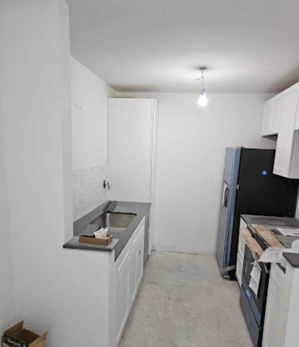 Kitchen layout showcasing white cabinetry and countertops