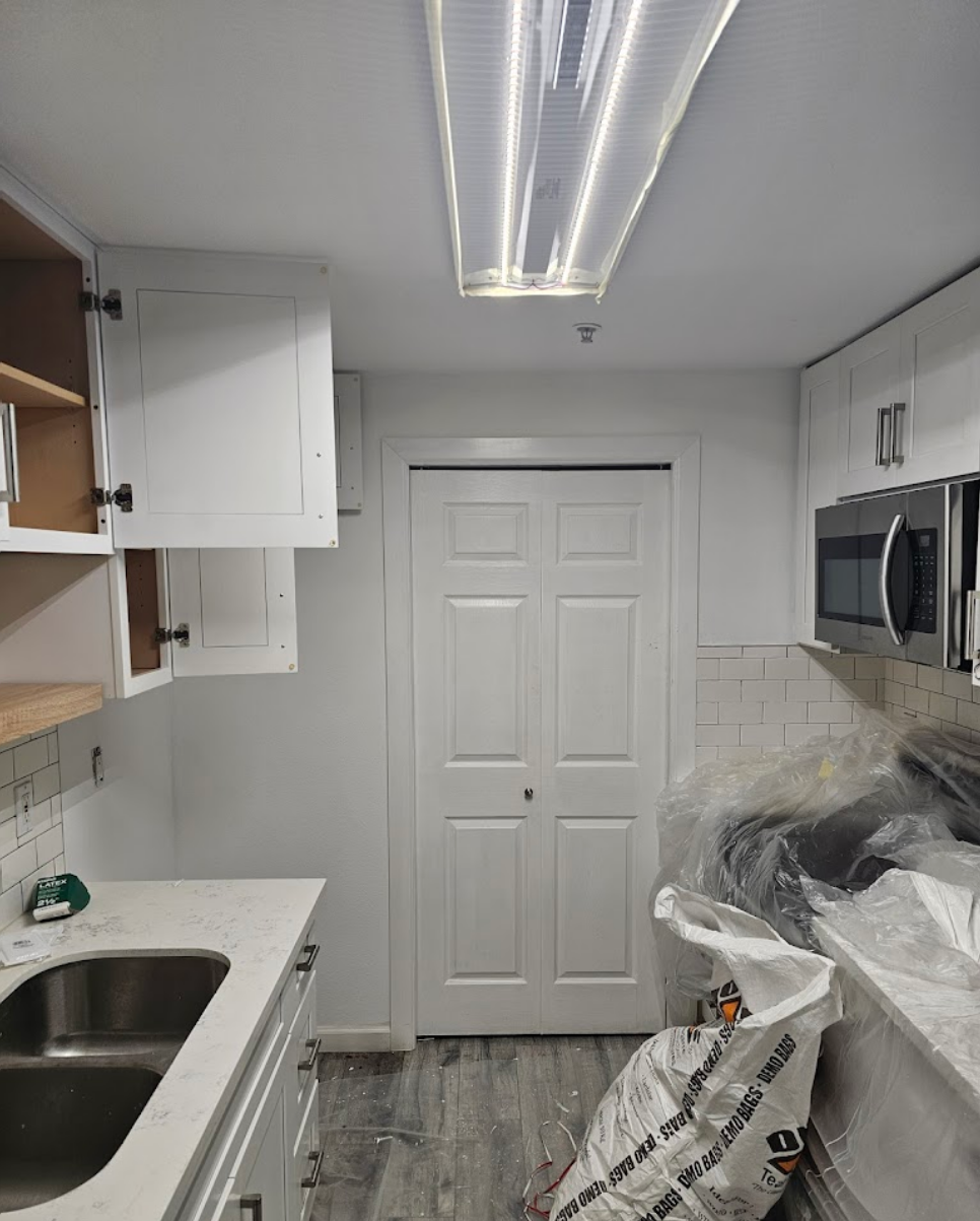 Compact kitchen layout with sleek white cabinets and appliances