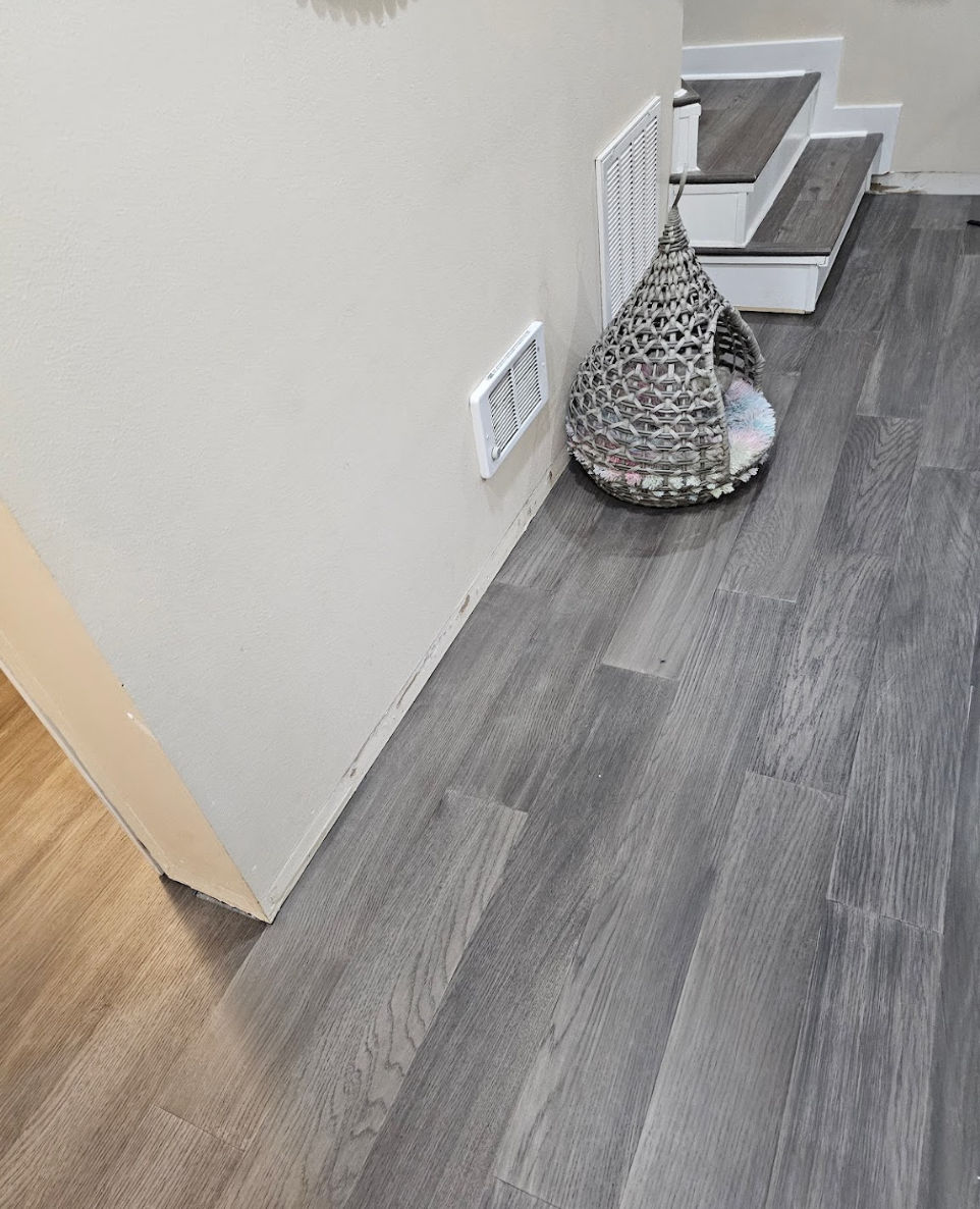 Staircase area with sleek flooring and crisp white walls