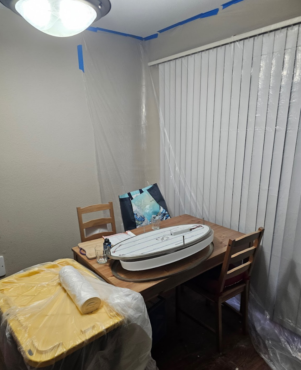 Dining area prepared for painting with furniture covered for protection